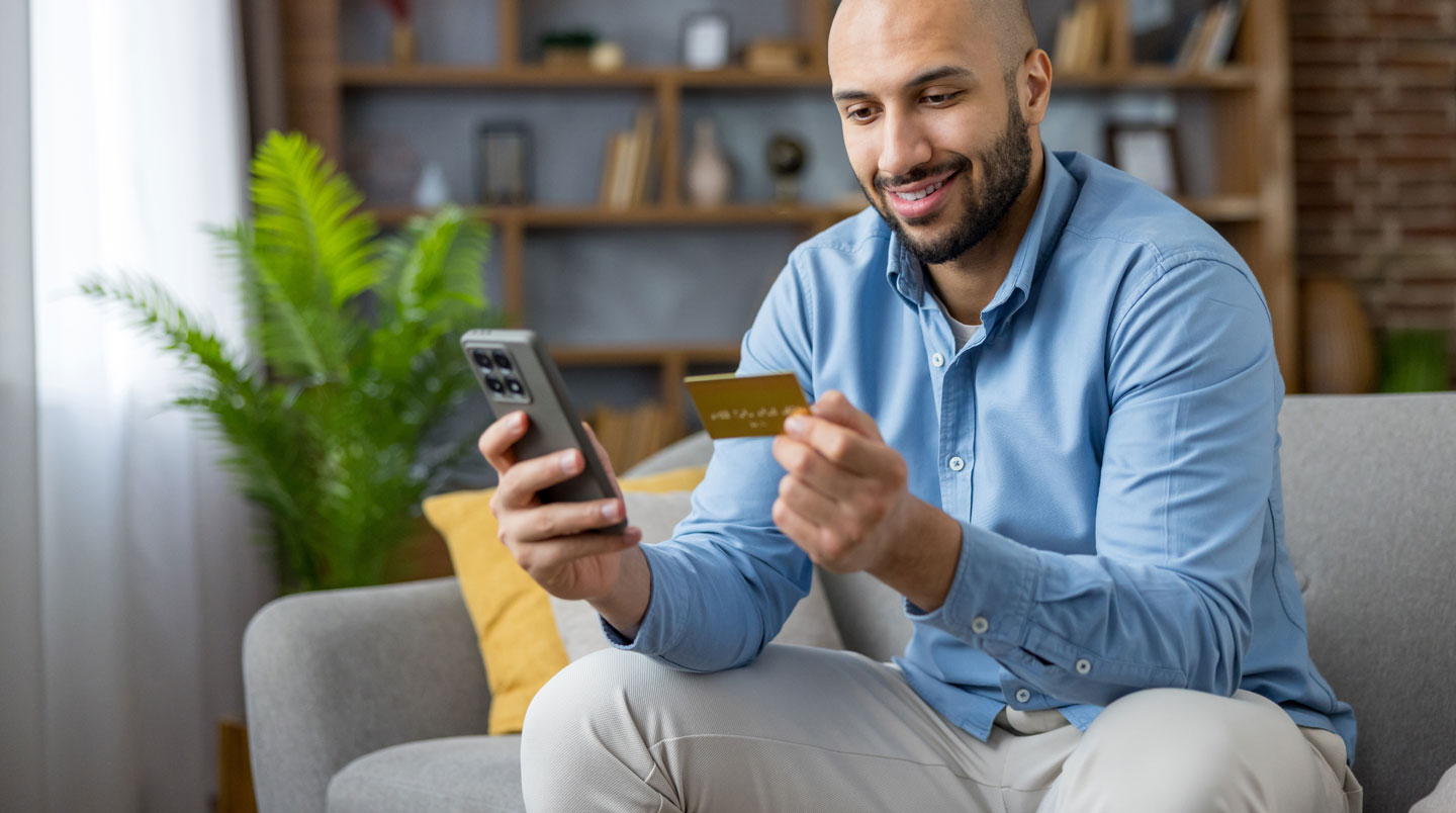 Main tenant un smartphone affichant l'application Banque Populaire avec le solde d'un compte CEL et l'historique de transactions